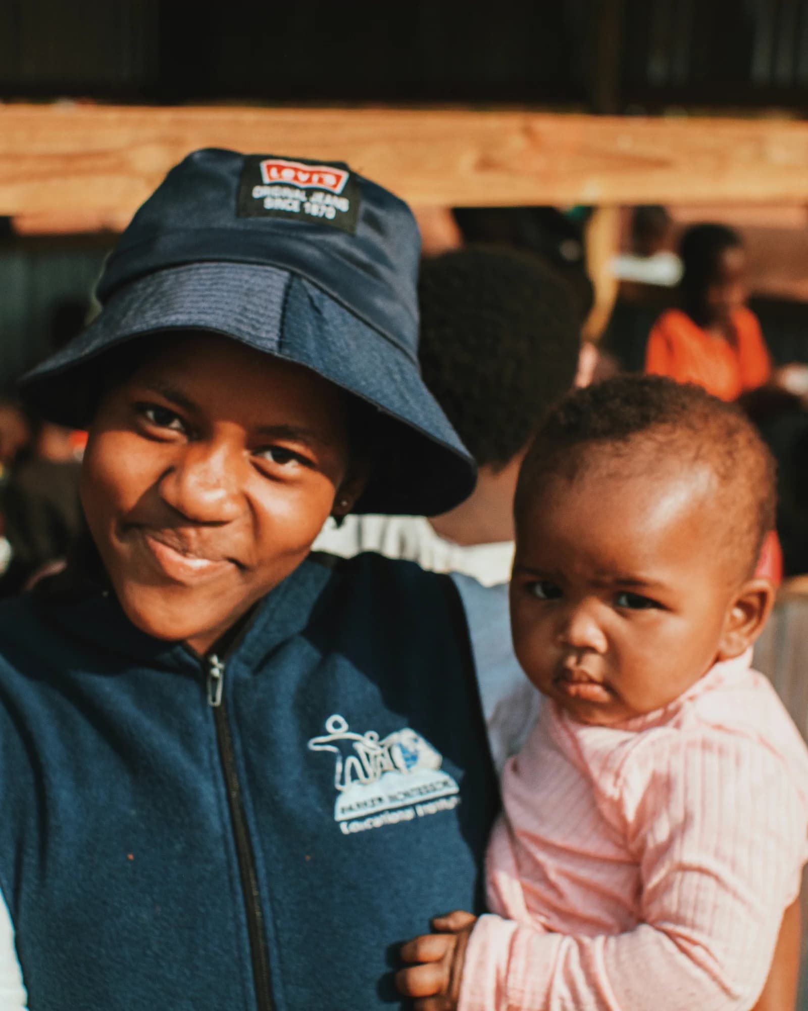 A smiling woman holding a young child in her arms.